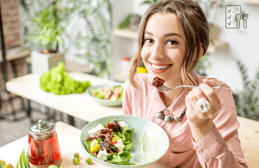 A picture of a girl eating a salad on a clean countertop and dining area