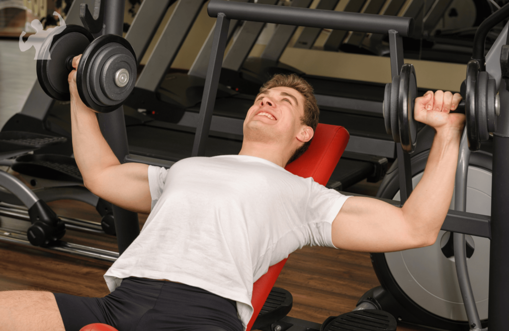 Image of a guy in the gym doing the incline dumbbell bench press workout