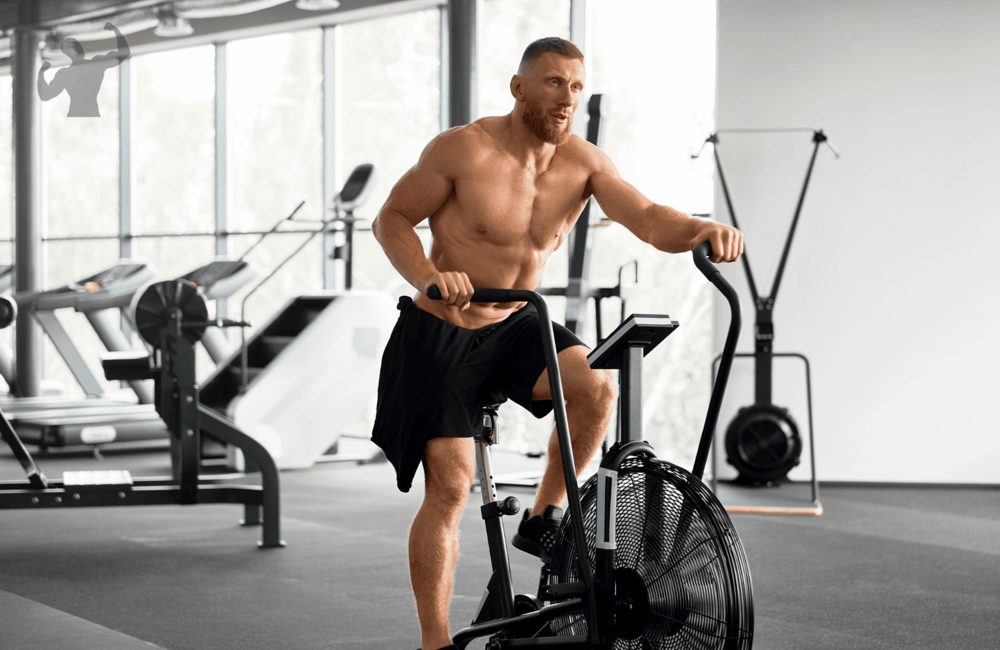 Image of a guy doing stationary bike in a gym as a warmup cardio before working out