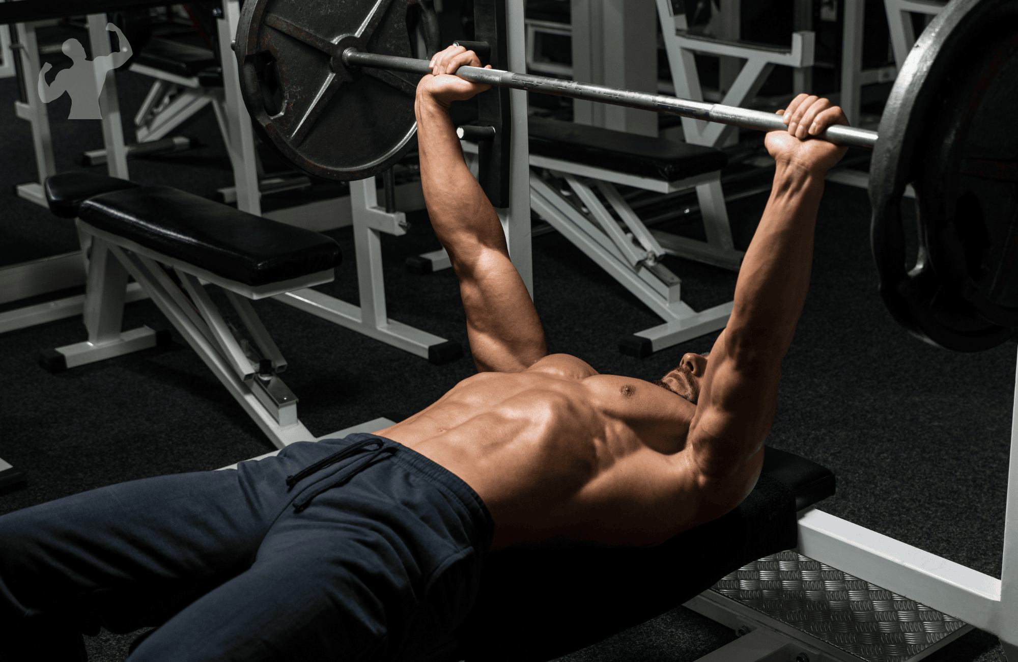 Image of a guy doing a barbell bench press workout in a clean gym