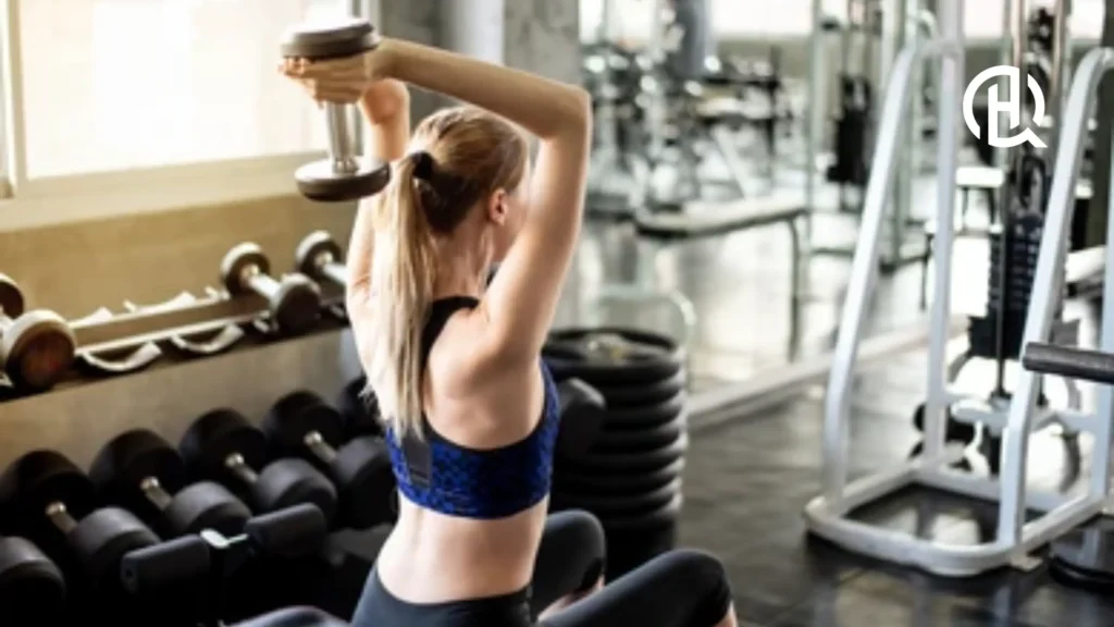 Girl doing dumbbell overhead extension.