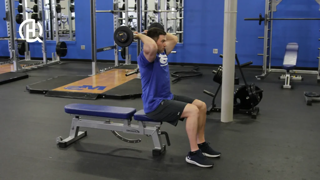 A person demonstrating the barbell french press