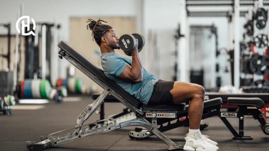 An image of a gym, the person are doing curls as he is leaning backwards for that extra stretch.
