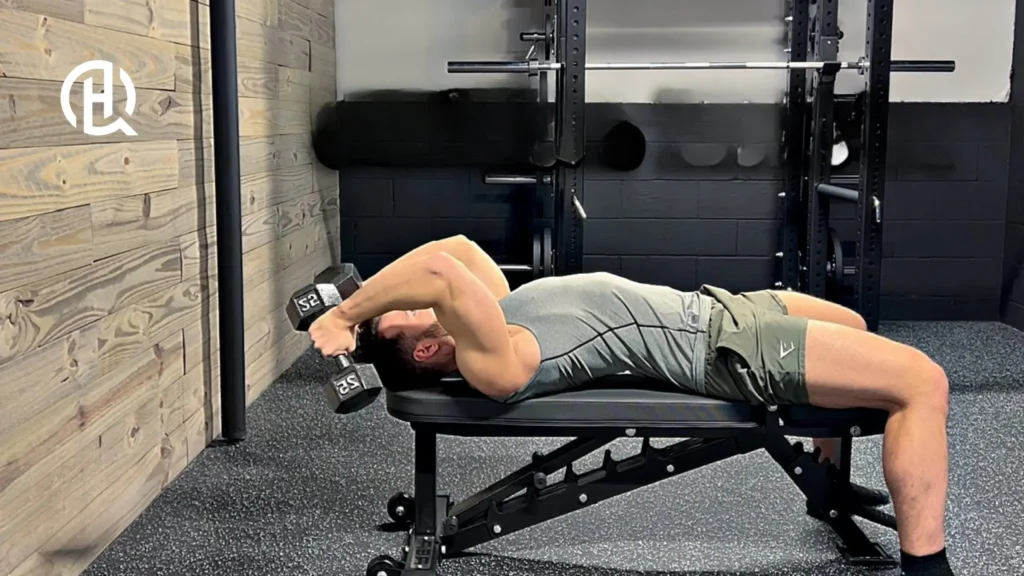 A man lying on a bench training arms.