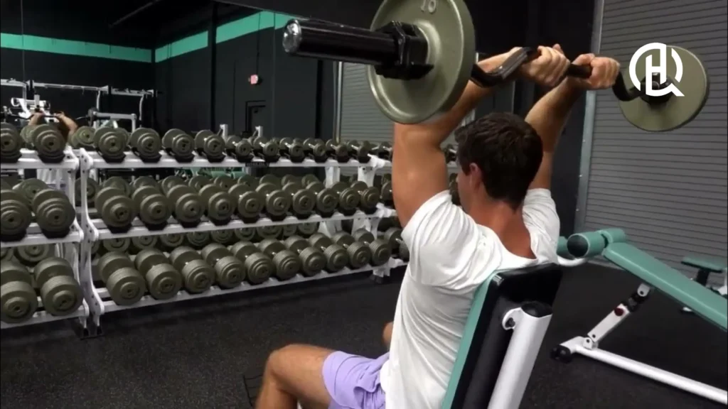Man doing Seated Barbell French Press in a gym