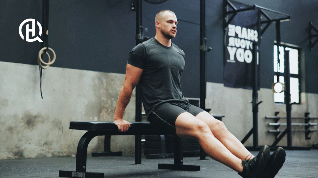 man doing Bench Dips. He is facing the camera.