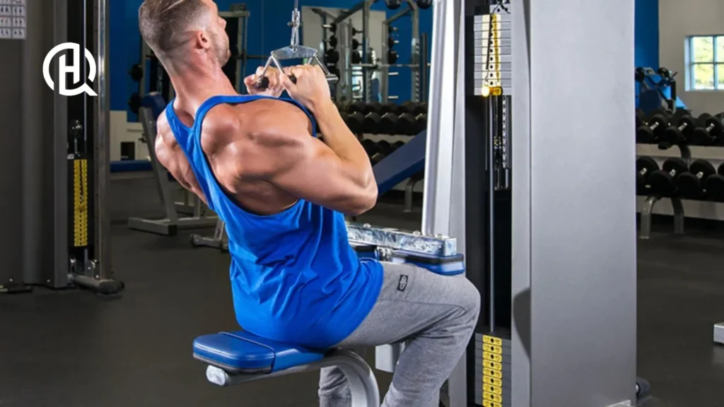 A person doing a lat pulldown. He wears a blue shirt.