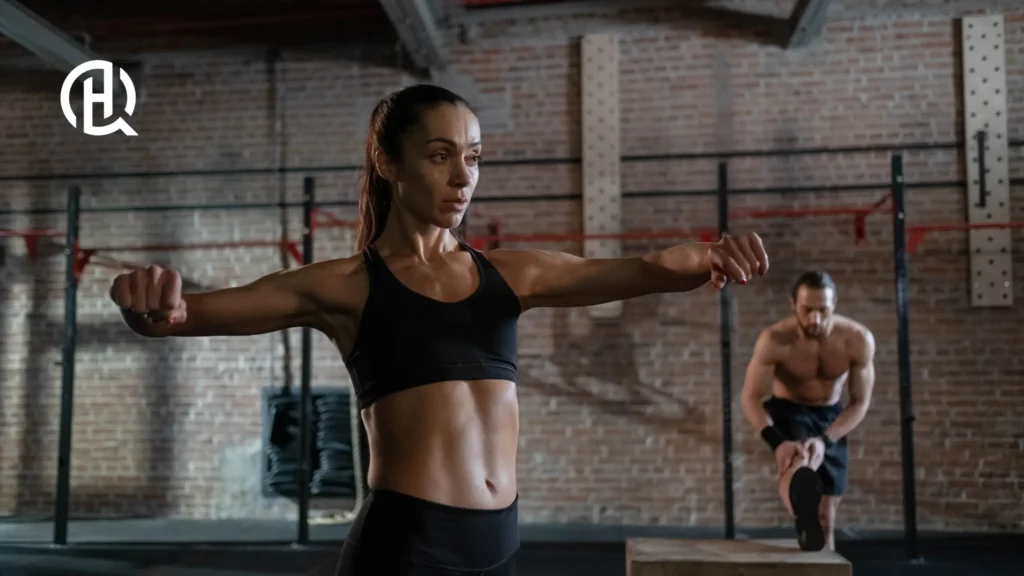 woman and Man working out. The woman are holding the arms out.