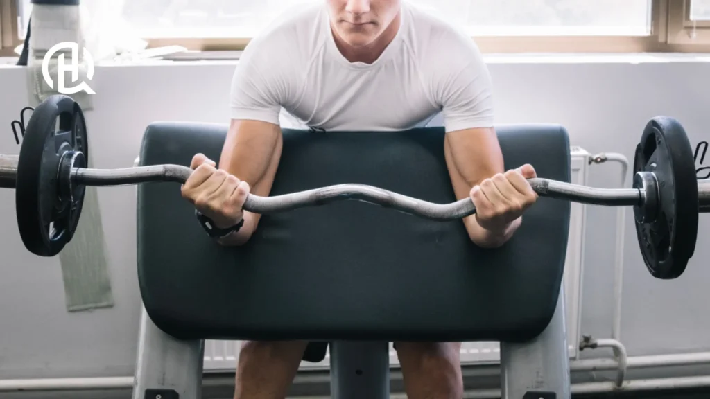 A person doing a bicep preacher curl with an ex bar.