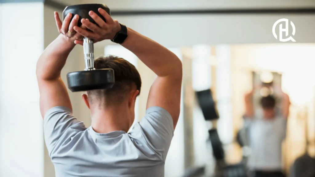 A man doing triceps dumbbell extension.