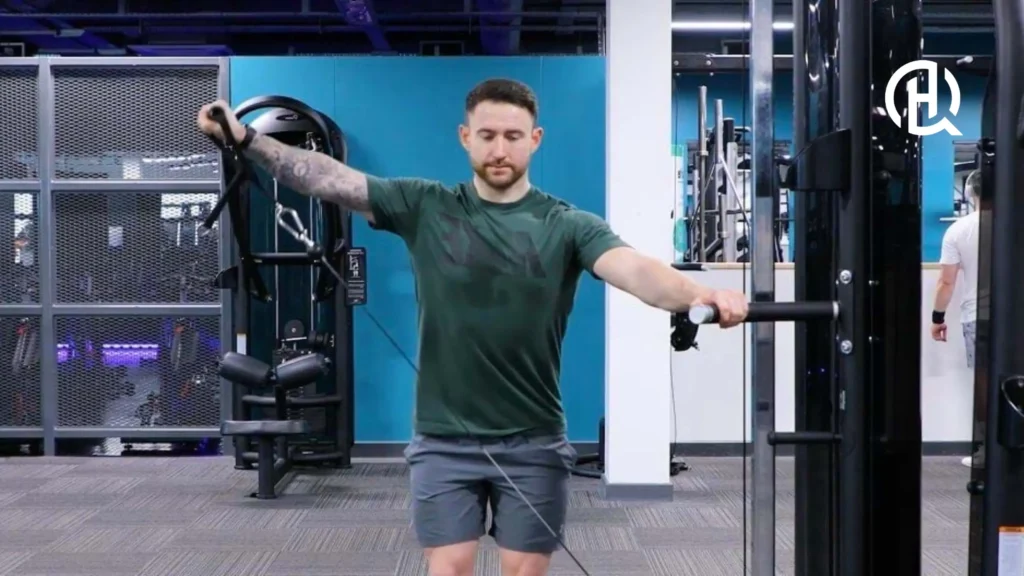 A person doing side laterals on a machine.