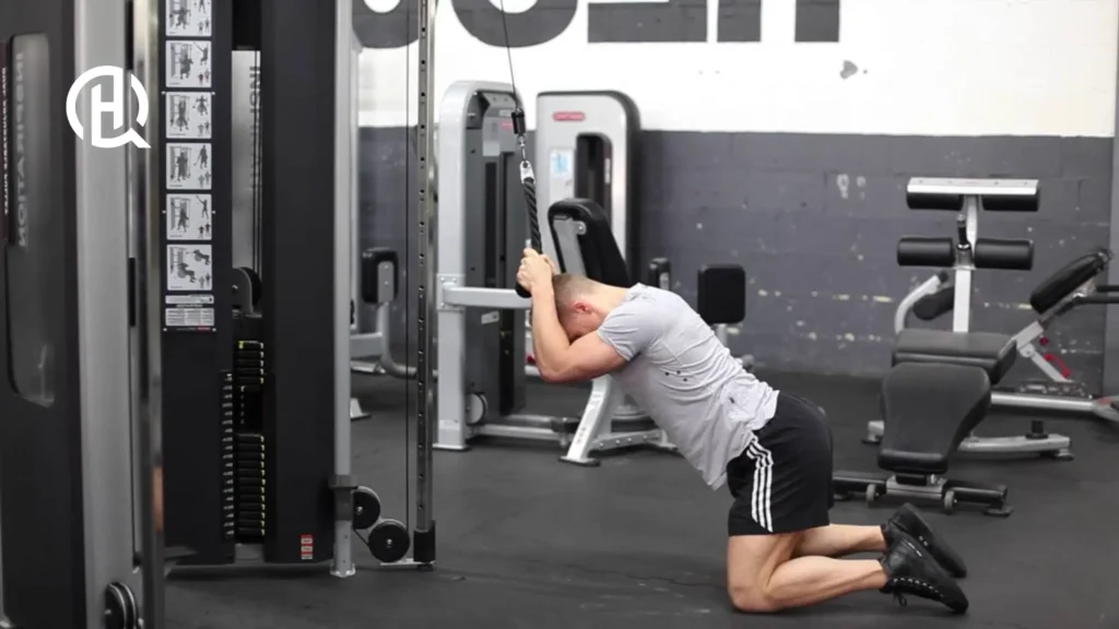 A trainer doing a cable crunch